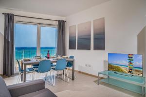 een woonkamer met een eettafel en een tv bij Appartamento Mare Blu a pochi passi dal mare in Balestrate