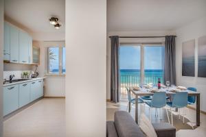 een keuken en een eetkamer met een tafel met uitzicht bij Appartamento Mare Blu a pochi passi dal mare in Balestrate