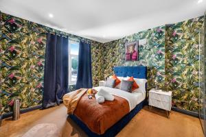 a bedroom with a large bed with colorful wallpaper at Newly Renovated Flat in London w/FREE Parking in Hendon