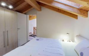 - une chambre avec un lit blanc et des plafonds en bois dans l'établissement Sur Crasta, à Celerina