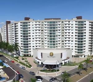 卡达斯诺瓦斯Riviera 1 Quarto的一座白色的大建筑,上面有花旗