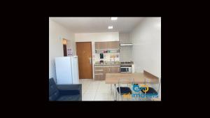 卡达斯诺瓦斯Riviera 1 Quarto的带桌子和冰箱的小厨房