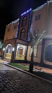 a hotel with a palm tree in front of a building at HOTEL ALIA in Djibouti