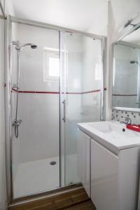 ein weißes Bad mit einer Dusche und einem Waschbecken in der Unterkunft Les Hauts de Thiers in Thiers