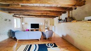 uma sala de estar com duas cadeiras e uma televisão em Moulin de charme Touraine #insolite #nature em Rivarennes