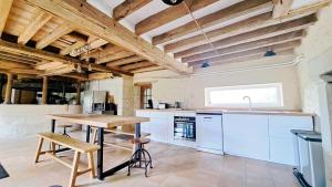 uma cozinha com armários brancos e uma mesa de madeira em Moulin de charme Touraine #insolite #nature em Rivarennes