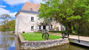uma antiga casa de pedra ao lado de um rio em Moulin de charme Touraine #insolite #nature em Rivarennes