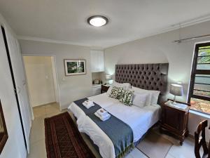 a bedroom with a large bed and a window at Jasmine Guest Cottage in Benoni