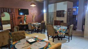 a dining room with tables and chairs and a tv at HOTEL ALIA in Djibouti