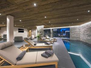 a living room with a swimming pool with couches at Luxury Apartment in Crans Montana by Dieckereise in Crans-Montana