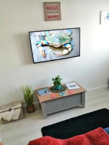 uma sala de estar com uma mesa e uma televisão na parede em The Blue Crab in Bournemouth em Bournemouth