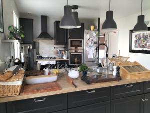 a kitchen with black cabinets and a wooden counter top at Étape au Chemin des Dames - Chambre et table d'hôtes in Pontavert