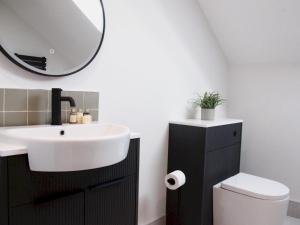 a bathroom with a sink and a mirror at Apartment 1 Old Conservative Club in Historic Town Pass the Keys in Caernarfon +43 photos