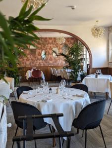 een eetkamer met tafels met witte tafelkleden bij Hotel du Saumon, Verneuil sur Avre in Verneuil d’Avre et d’Iton