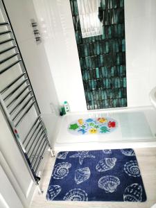 a bathroom with a shower and a blue rug at The Blue Crab in Bournemouth in Bournemouth