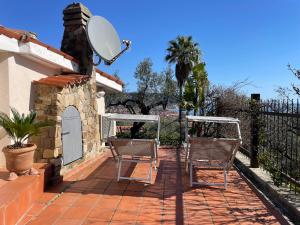 a patio with two chairs and a satellite at Villa Panorama in Diano Marina