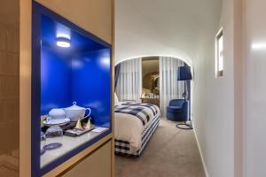 Hästens Sleep Experience FLH Hotels Coimbra في كويمبرا: غرفة نوم مع غرفة زرقاء مع سرير ومرآة