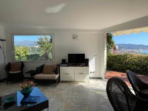 a living room with a tv and a large window at Villa Panorama in Diano Marina