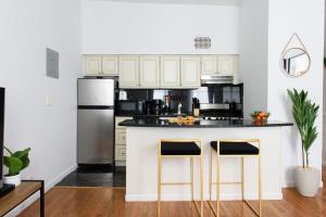 a kitchen with a refrigerator and two bar stools at 26-2B Gramercy Large 1BR WD in unit courtyard in New York