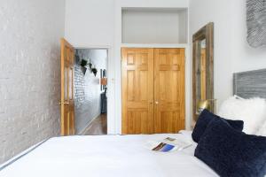 - une chambre avec un lit blanc et une porte en bois dans l'établissement 26-2B Gramercy Large 1BR WD in unit courtyard, à New York