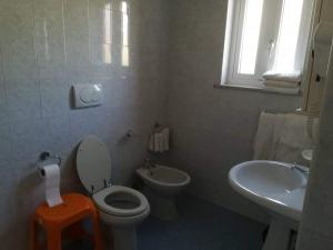 Baño blanco con aseo y lavamanos en Casa La Perla en Ischia