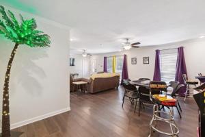 una sala de estar con una mesa y una palmera en LSU Slammer Arcade 4 5 mile to LSU Private Yard en Baton Rouge