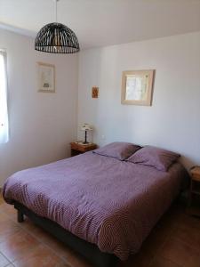 1 dormitorio con 1 cama con manta morada en MAISON SPACIEUSE PRES DES PLAGES, en Audierne