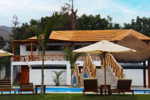 a resort with chairs and umbrellas and a swimming pool at Los Andes - Restaurant & Bungalows in Cieneguilla