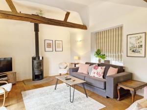 a living room with a couch and a tv at Holme Street House and Dove Cote Lodge in Pulborough