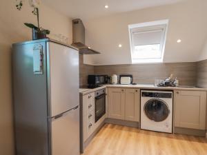 cocina con nevera y lavavajillas en Purlie Lodge Apartment en Inverness
