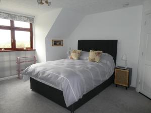um quarto com uma cama grande e uma janela em Purlie Lodge Apartment em Inverness