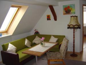 un soggiorno con divano verde e tavolo di Ferienwohnung in Domsühl a Domsühl
