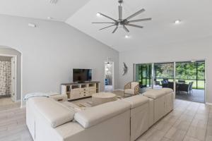 Sala de estar blanca con sofá grande y mesa en Eastwood | Palm Coast, en Palm Coast