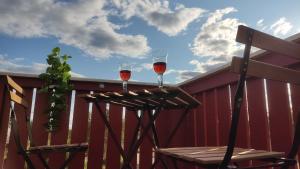 zwei Gläser Wein auf einem Holztisch in der Unterkunft Buntes Schwedenhaus Lillebror in Fågelfors