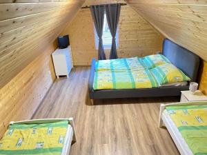 een slaapkamer met 2 bedden in een houten huis bij Apartmán Trícia-Ebiky-Jedlo a Pit-Centrum in Heľpa