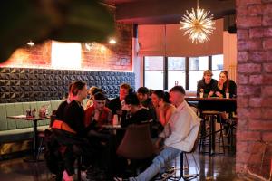 a group of people sitting at tables in a restaurant at Revolver Glasgow in Glasgow