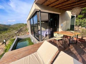 Casa con mesa de madera y piscina en Glamping Cabaña de Lujo, en Girón