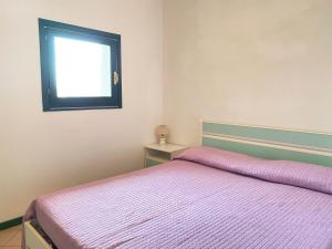 a bedroom with a bed and a window at Appartamento in complesso con piscina in Santa Teresa Gallura