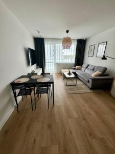 sala de estar con sofá y mesa en Apartament Zachodni, en Słupsk