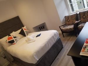 Mayfield Suites في إدنبرة: غرفة نوم مع سرير مع ريموت كنترول عليه