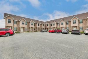 a large building with cars parked in a parking lot at Pet-Friendly Edinburg Townhome - Near Stadiums! in Edinburg