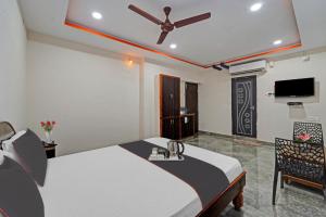 a bedroom with a bed with a ceiling fan at Capital O Hotel Lakshmi Residency in Tirupati