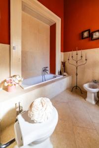 y baño con bañera, aseo y lavamanos. en Dimora Storica Giostra Vecchia - Palazzo Grisolia 1809 en Cosenza