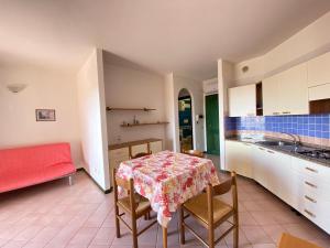 a kitchen and dining room with a table and chairs at Appartamento in complesso con piscina in Santa Teresa Gallura