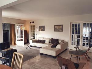 ein Wohnzimmer mit einem Sofa und einem Tisch in der Unterkunft Appartement et Maison Espace Mayenne in Laval