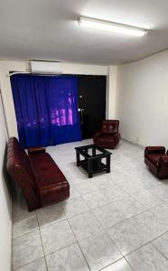 a living room with leather chairs and a table at Clotilde Depto Completo in Posadas