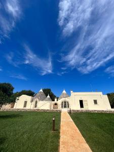 切列梅薩皮卡的住宿－Trullo Rosa del Sud-Benessere SPA，蓝色天空的白色大建筑