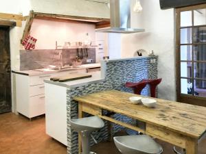 eine Küche mit einem Holztisch und einigen Stühlen in der Unterkunft Maison de 5 chambres avec piscine partagee jardin clos et wifi a Saint Andre de Cruzieres in Saint-André-de-Cruzières