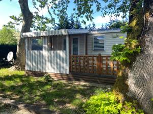 a small house with a fence and a tree at Mobilhome 516 in La Teste-de-Buch