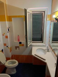 een badkamer met toilet, wastafel en raam bij Il Marinaio in Messina +20 foto's